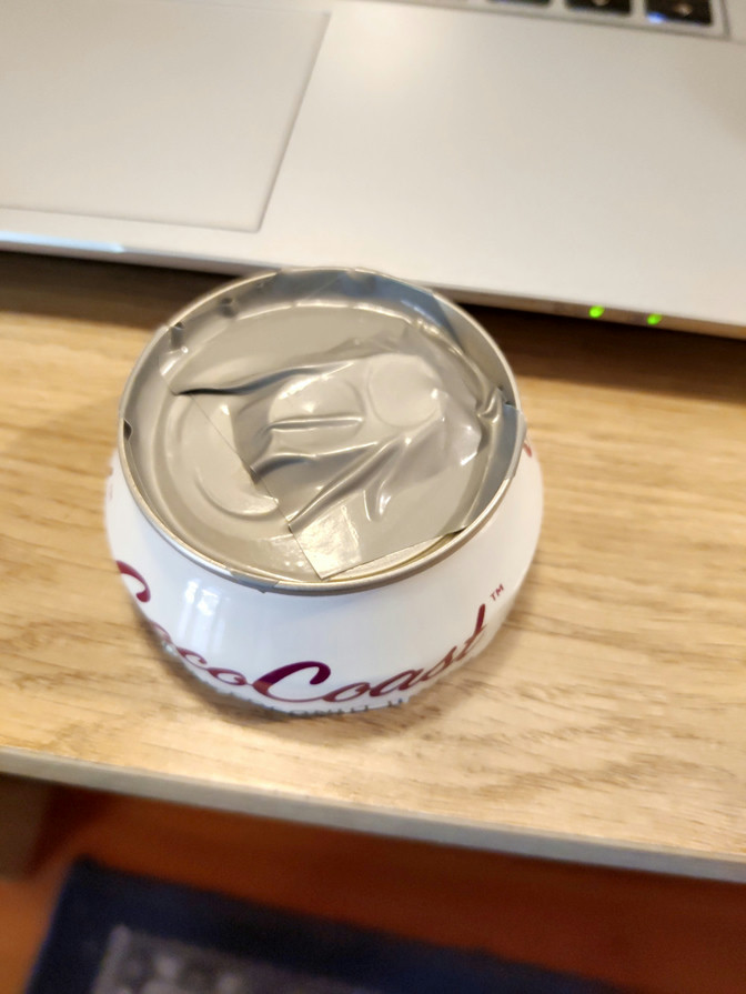 The top of a coconut water can with sticky tape sealing the outside